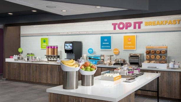 A breakfast area with a counter displaying various food items and a sign that reads "TOP IT BREAKFAST". - Tru by Hilton San Antonio North (San Antonio)