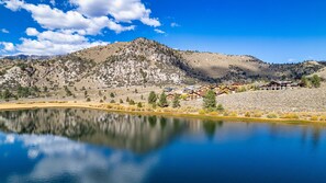 A lakeside view of a mountain with a resort featuring multiple buildings with wooden exteriors and a clear sky. - Interlaken 32 overlooking the lake and Sierra. (June Lake)
