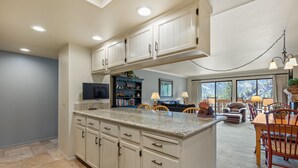 A spacious kitchen with granite countertops, white cabinetry, and a large island.