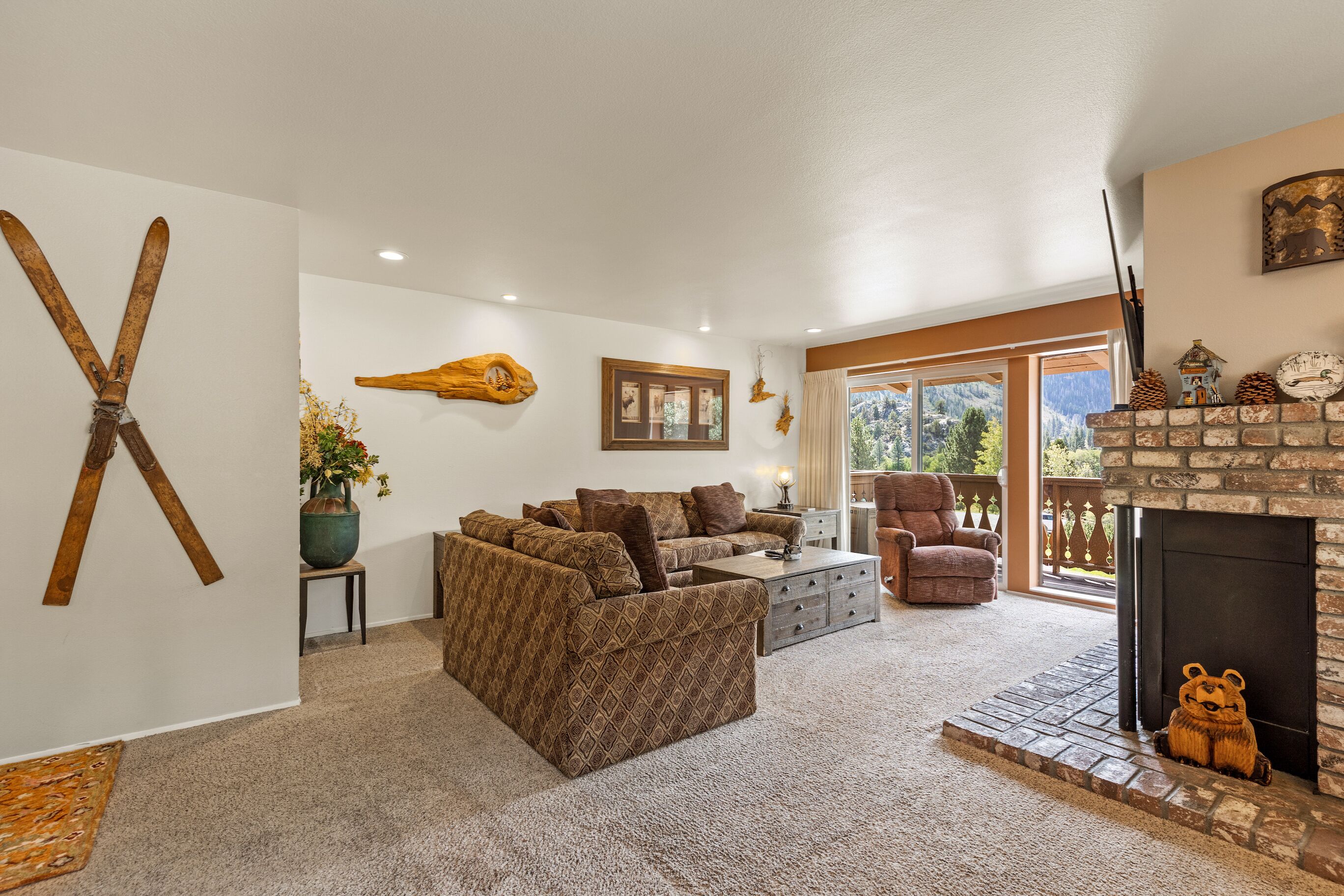 A cozy living room with a fireplace, a large sofa, and a dining area.