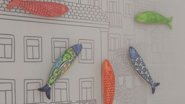 Un bâtiment dont l’architecture est représentée par un plan détaillé, et sur lequel on peut voir différents modèles de poissons aux couleurs vives.