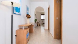 A hallway with a wooden desk, a lamp, and framed artwork on the wall. - Home2book Sea Front El Granillo, Beach & Wifi (Costa Calma)