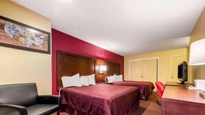 A hotel room with two beds, a desk with a computer, a chair, and a painting on the wall. - Ramada Limited Gilroy (Gilroy)