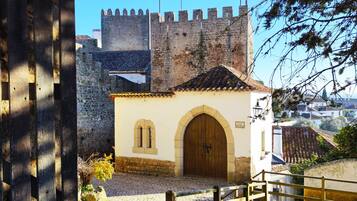 A historic building with a large wooden door and a stone wall in the background.