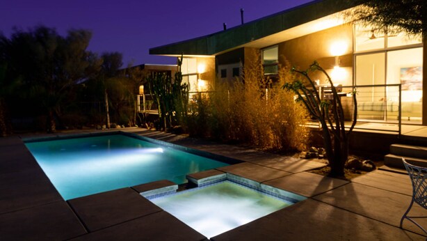 Ein modernes Haus mit Schwimmbad im Abenddämmerung.