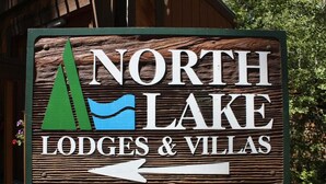 En skylt för North Lake Lodges & Villas, med en pil som visar riktningen.