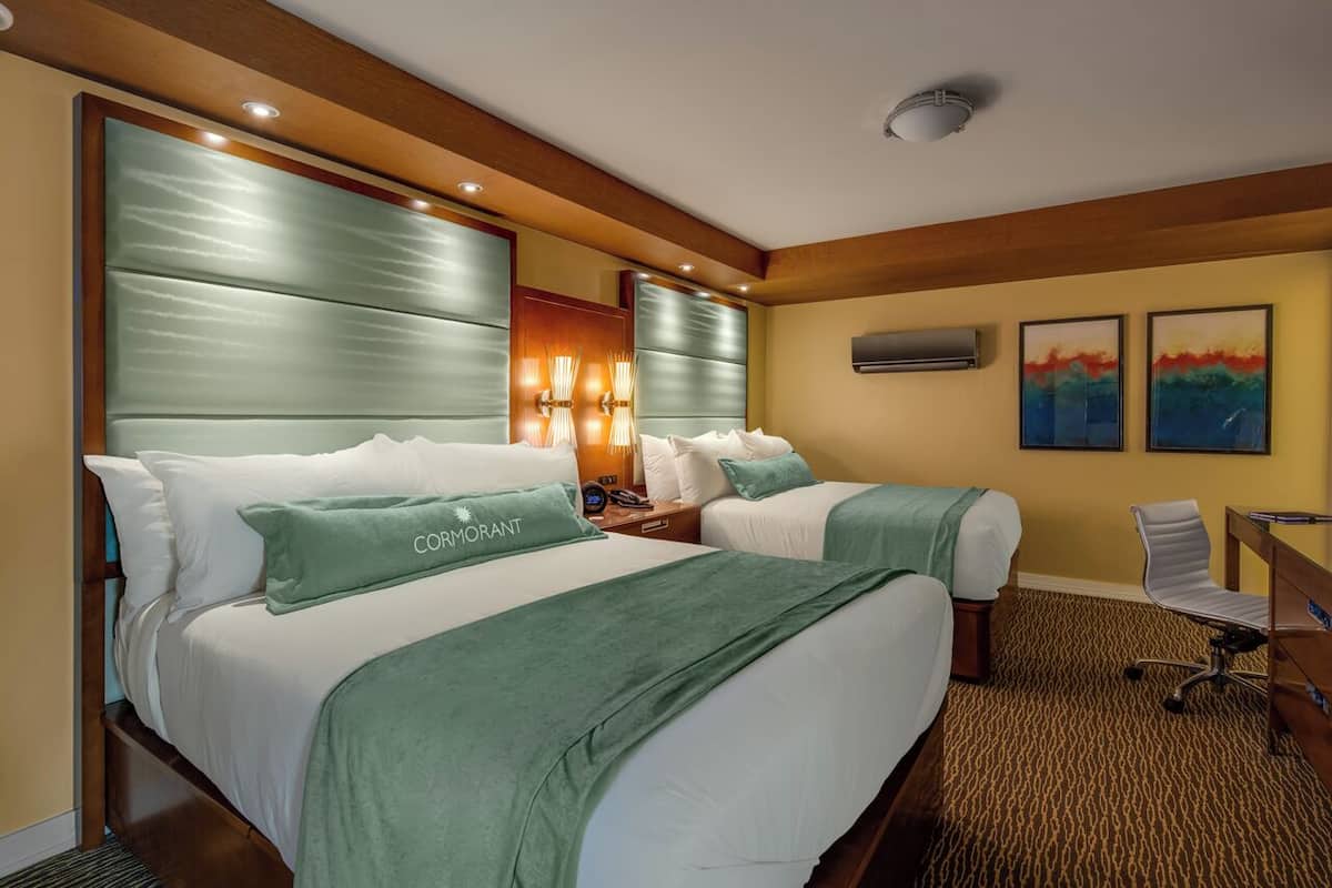 Una habitación de hotel con dos camas, un escritorio y una silla.
