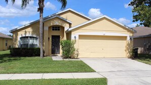 A single-story house with a garage, a front door, and a small front yard. - Just Keep Swimming - NEW Pool Home (Davenport)