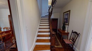 A staircase with wooden steps and a handrail, leading to an upper floor.