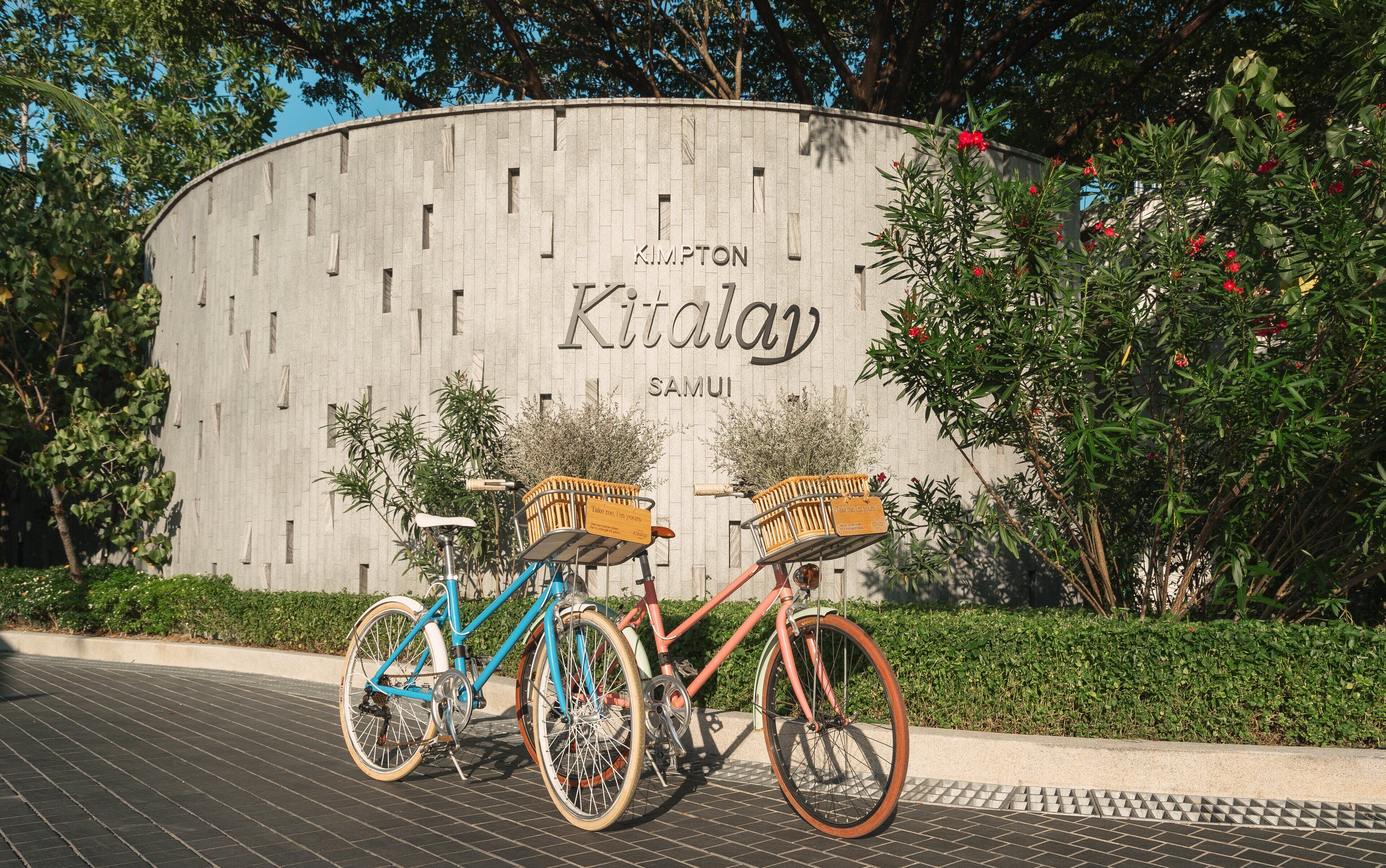 En byggnad med en skylt som visar texten ”KIMALAY SAMUI” och två cyklar parkerade framför.