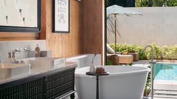 Bathroom features a bathtub, large mirror, and vanity with a countertop.