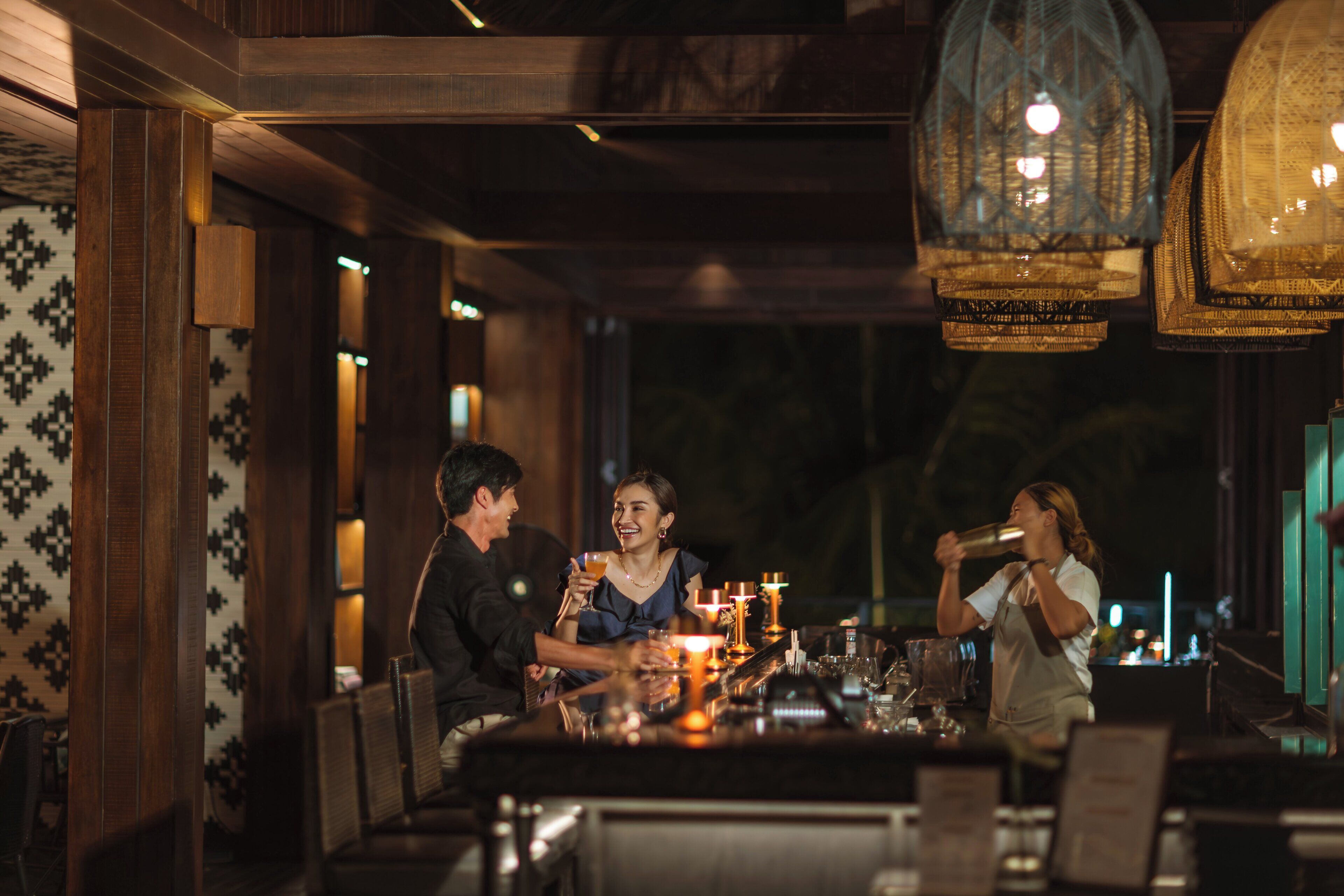Un restaurante tenuemente iluminado con decoración de madera y faroles colgantes.