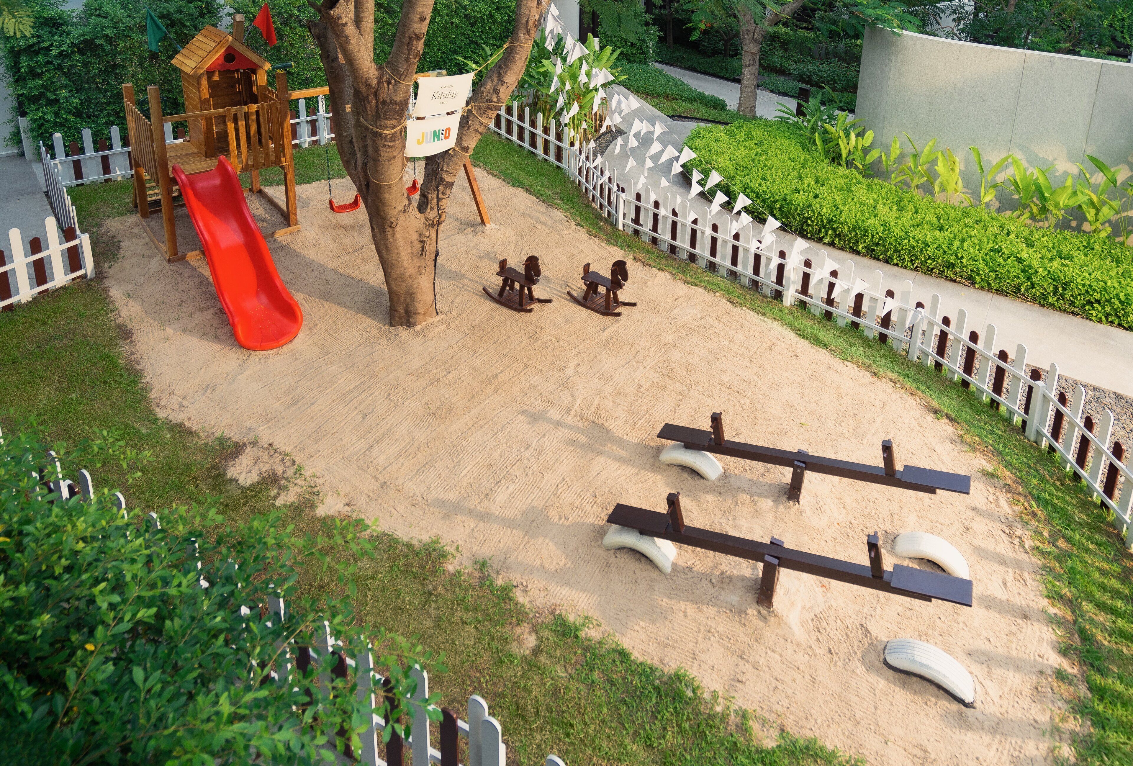 A playground with a slide, swings, and seesaws.