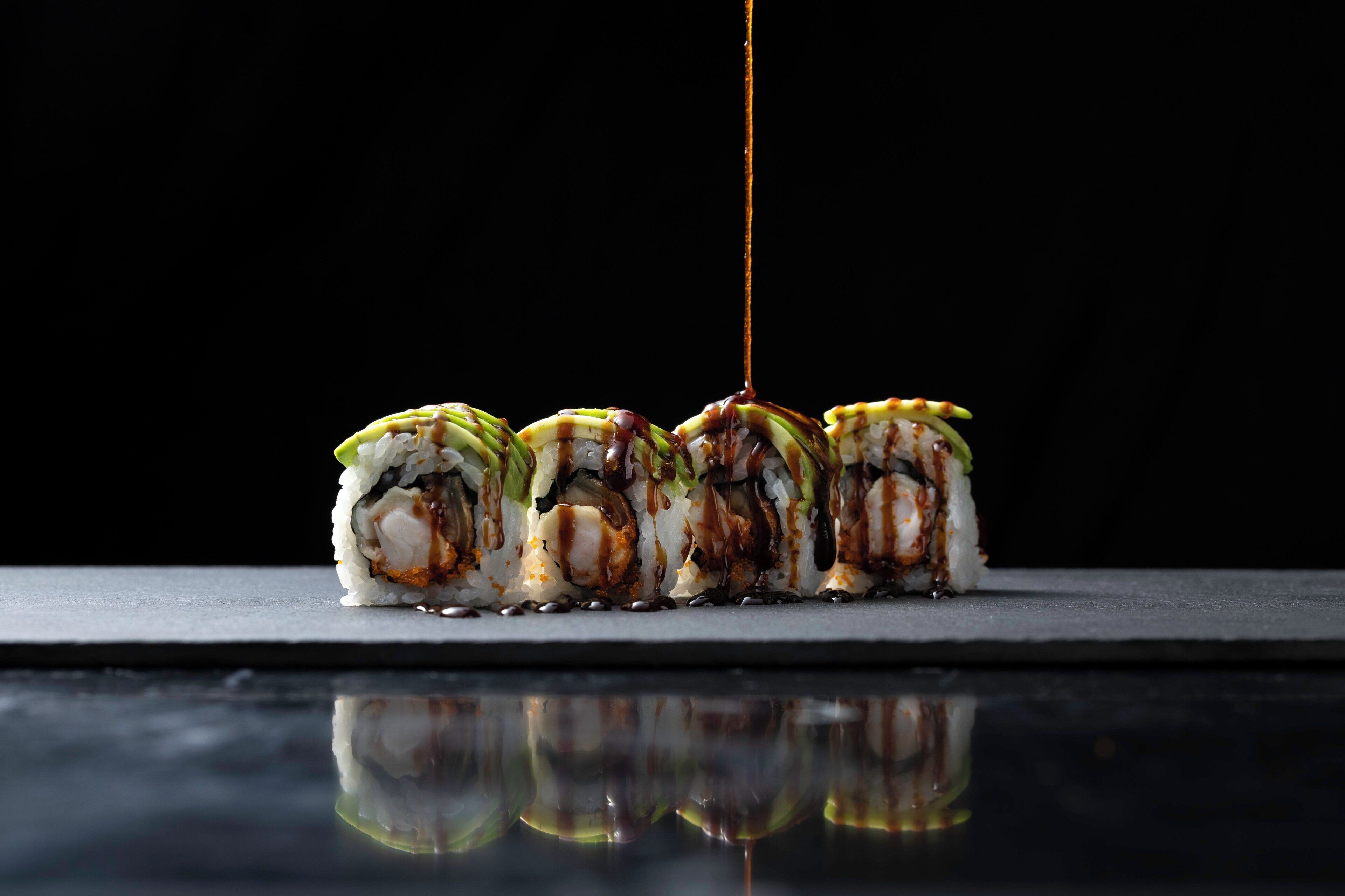 A sushi dish with sauce being poured over it.
