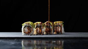 A sushi dish with sauce being poured over it.