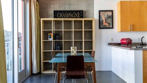 Une cuisine moderne avec une table en verre, des meubles de rangement en bois et un panneau publicitaire pour du champagne.