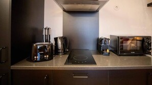 A modern kitchen with a built-in stove, a coffee maker, and a toaster. - Lemago Porto Apartments - POVEIROS 2B (Porto)