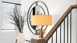 A staircase with wooden steps and black railings, leading to a landing with a white vase and branches, and a round mirror on the wall. - Spacious and Affordable Townhome, 5 BD/4.5 BA at The Vue in St. George (St. George)