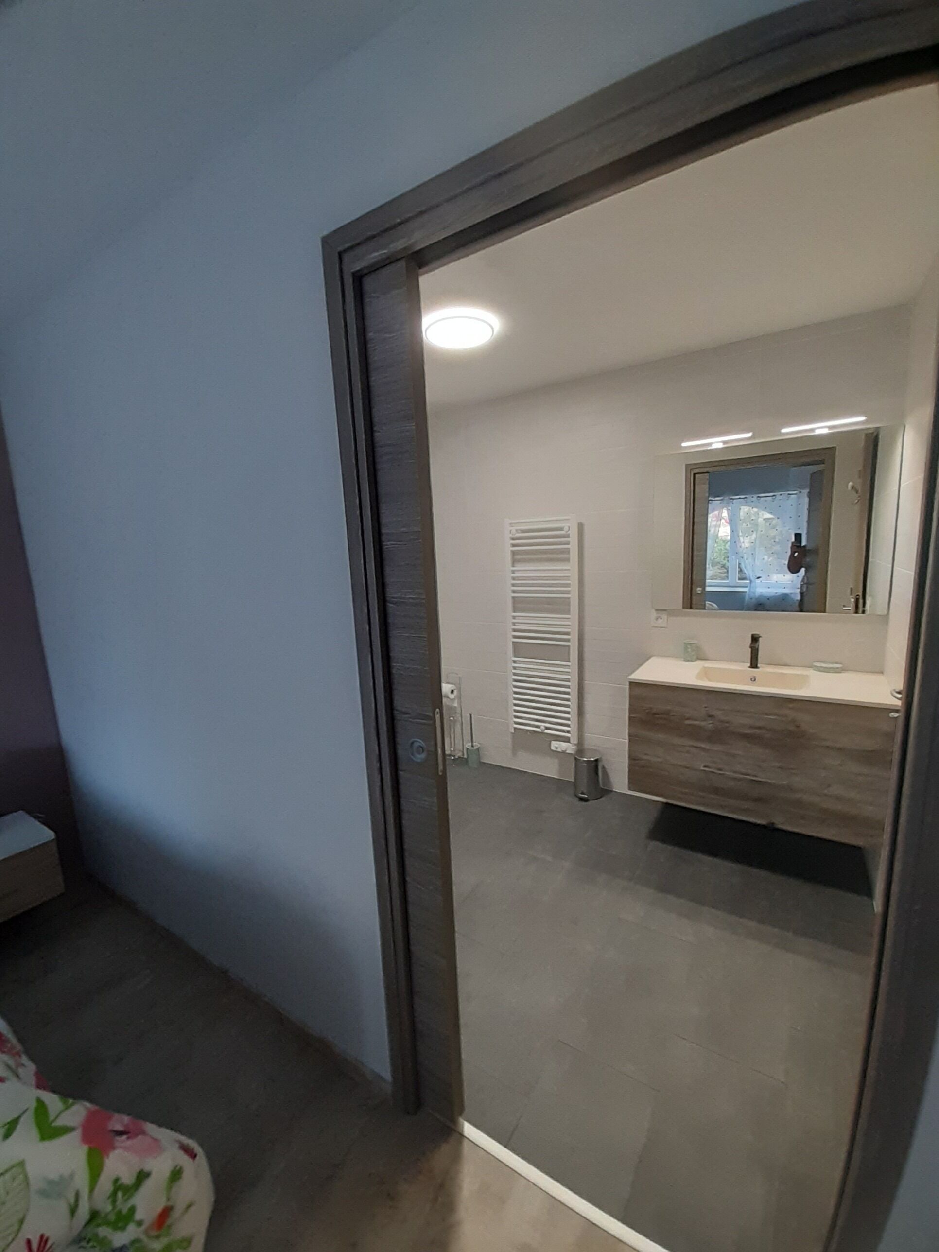 Un bagno moderno con un mobile lavabo, uno specchio e un water.