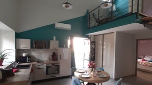 Una cocina moderna con comedor, una escalera y vistas al exterior.