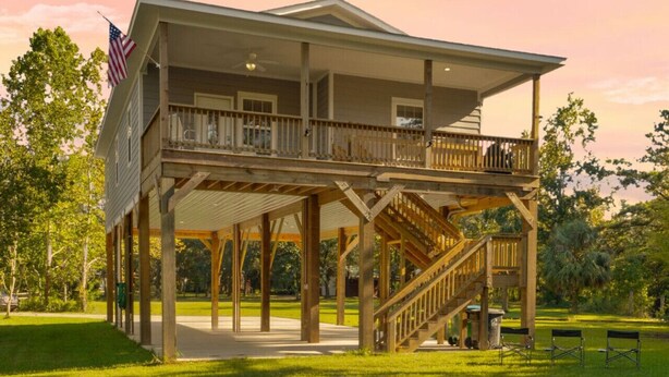 A two-story building with a balcony and a covered porch.