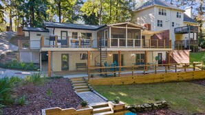 A two-story house with a covered patio, outdoor seating, and a spiral staircase.