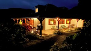 Ein Haus mit überdachter Veranda, Essbereich und Grill.