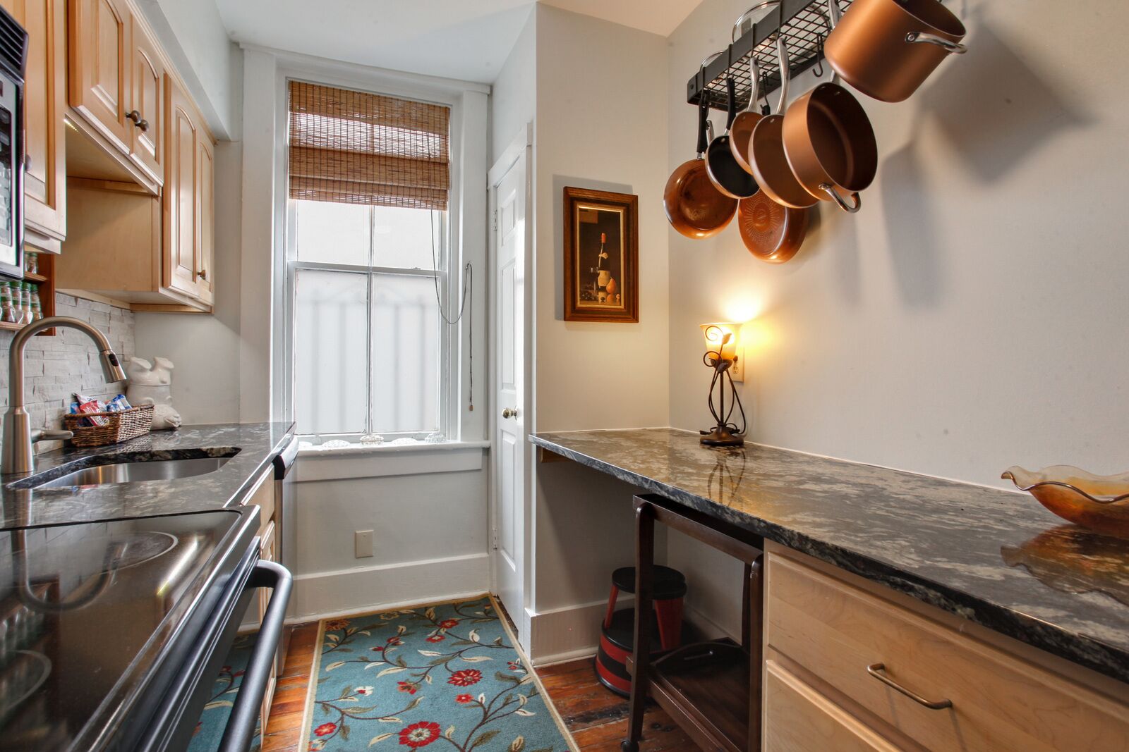 A kitchen with a window, a sink, a stove, and a countertop.