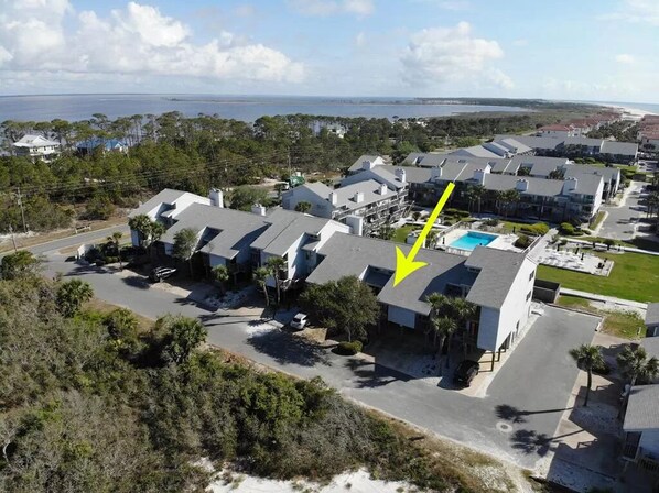 Um bairro residencial com várias casas, piscina e vista para o oceano.