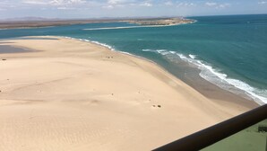 A beach with clear blue water and a sandy shore.