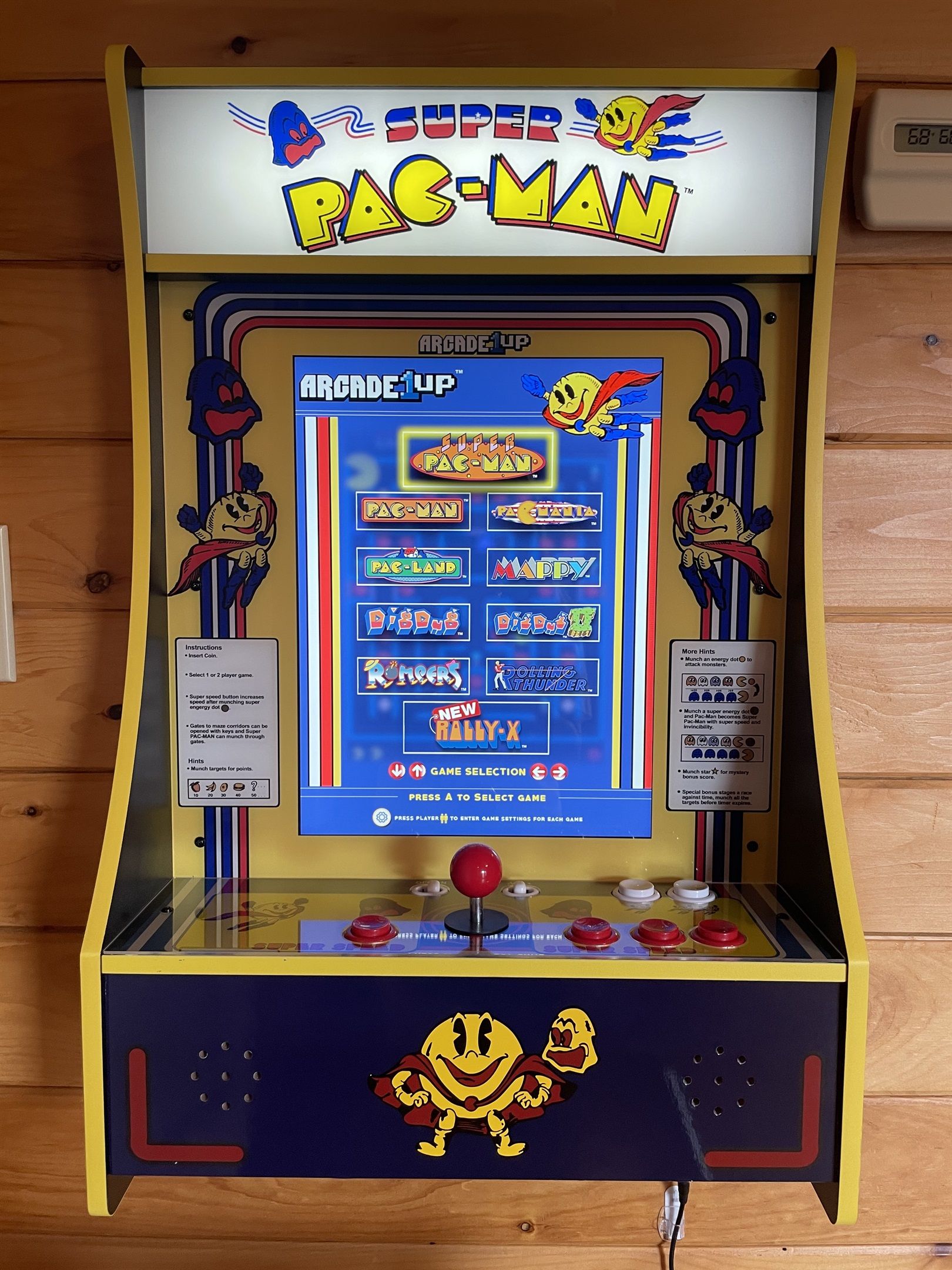 A vintage arcade machine with a yellow and blue color scheme, featuring the Pac-Man logo and multiple game options.