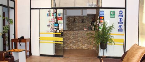 A reception area with a stone wall, a reception desk, and a seating area with leather chairs.