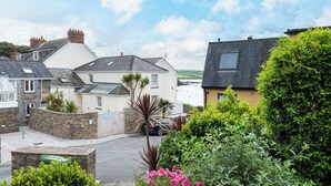 A residential area with houses, a stone wall, and a driveway.
