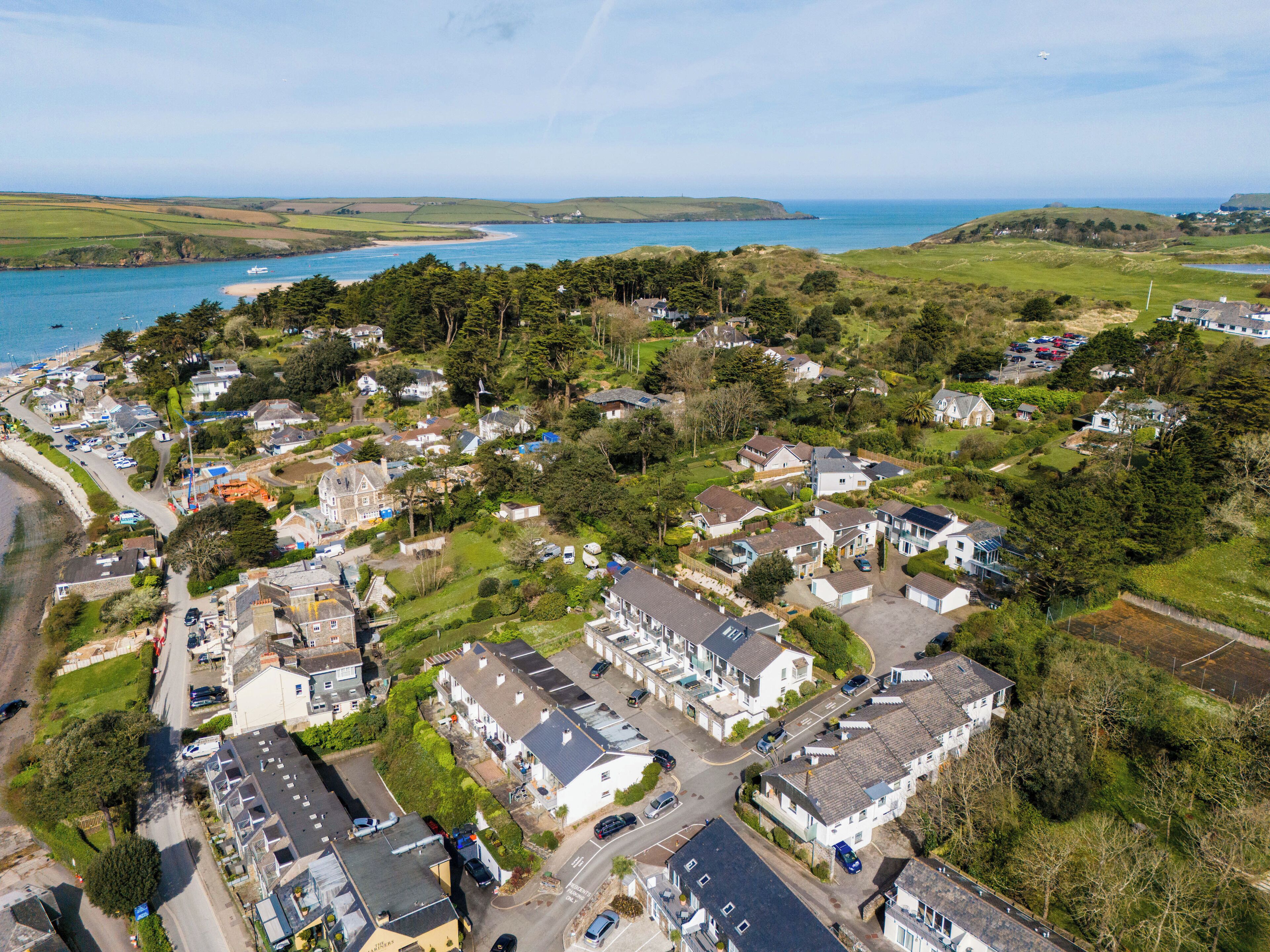 A coastal residential area with houses, roads, and a beach.