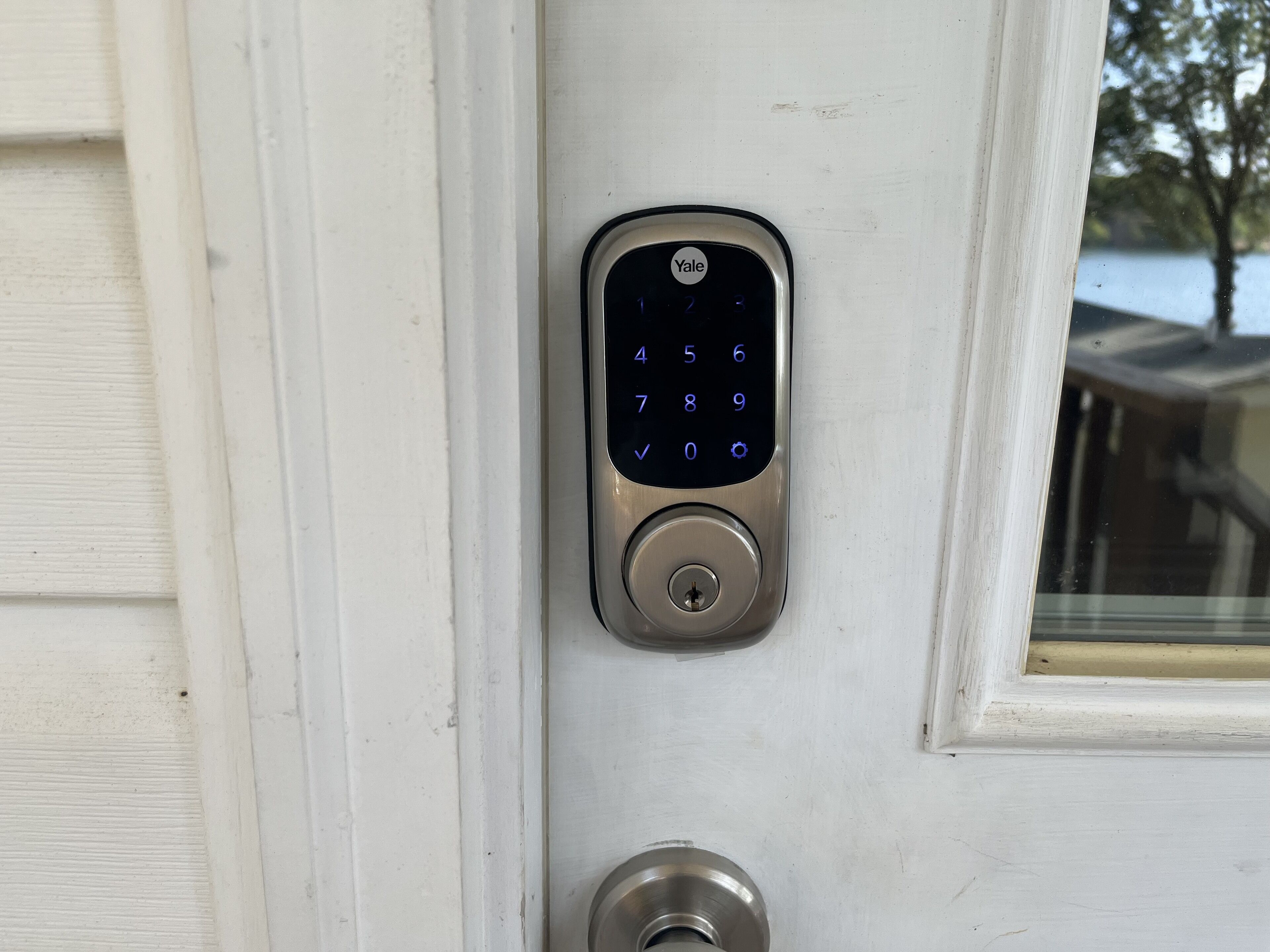 Una cerradura inteligente Yale en una puerta blanca.