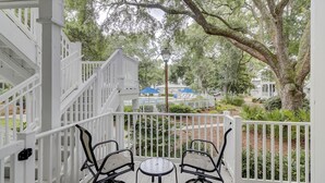 A covered outdoor area with a white railing, two chairs, and a small table. - Beach Luxury Villa w/ Free Golf & Tennis plus Westin Resort Amenities! (Hilton Head Island)