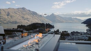 Une vue panoramique d’un paysage montagneux avec un lac, un pont et une ville au premier plan.