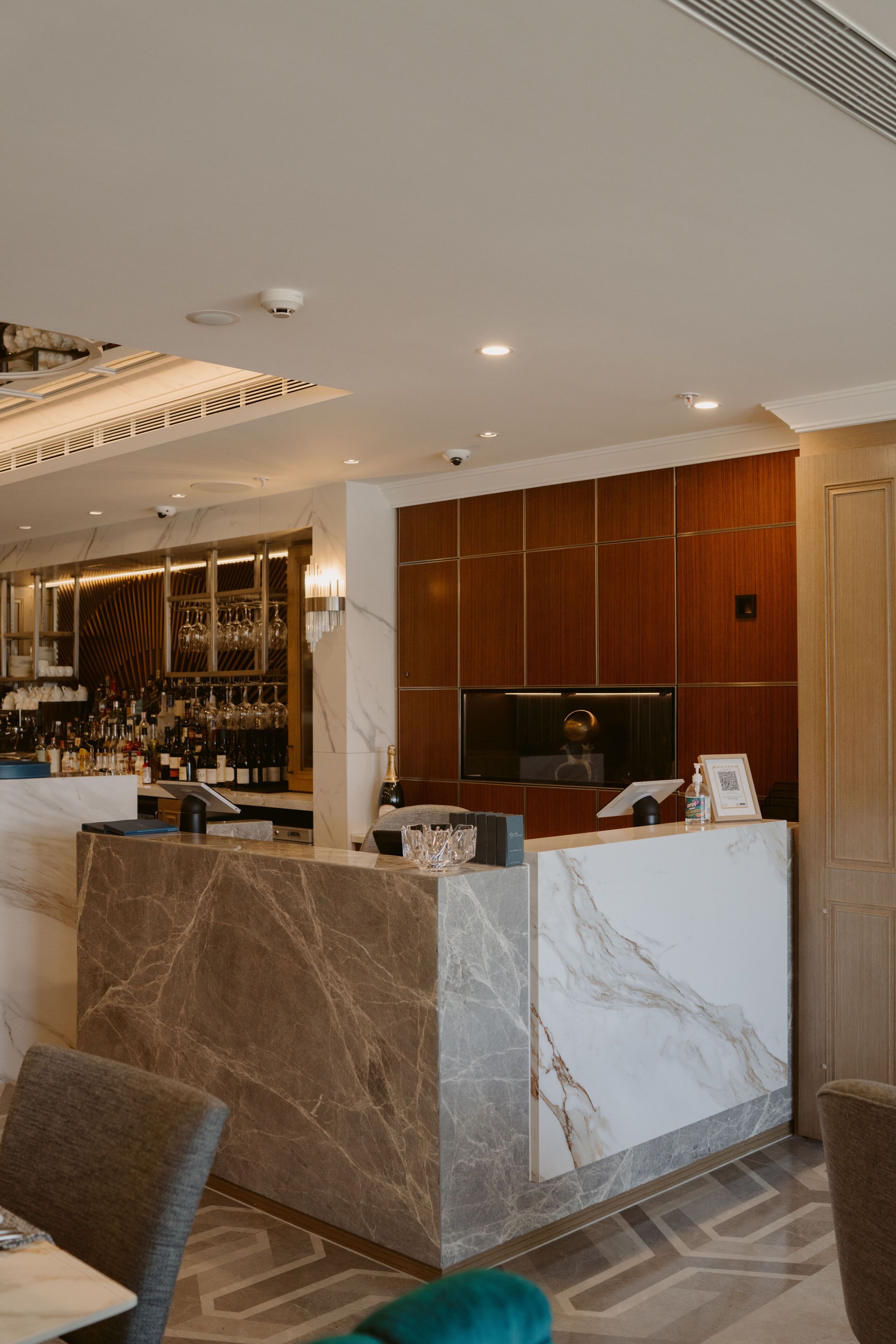 A hotel lobby with a reception desk, a bar area, and seating.