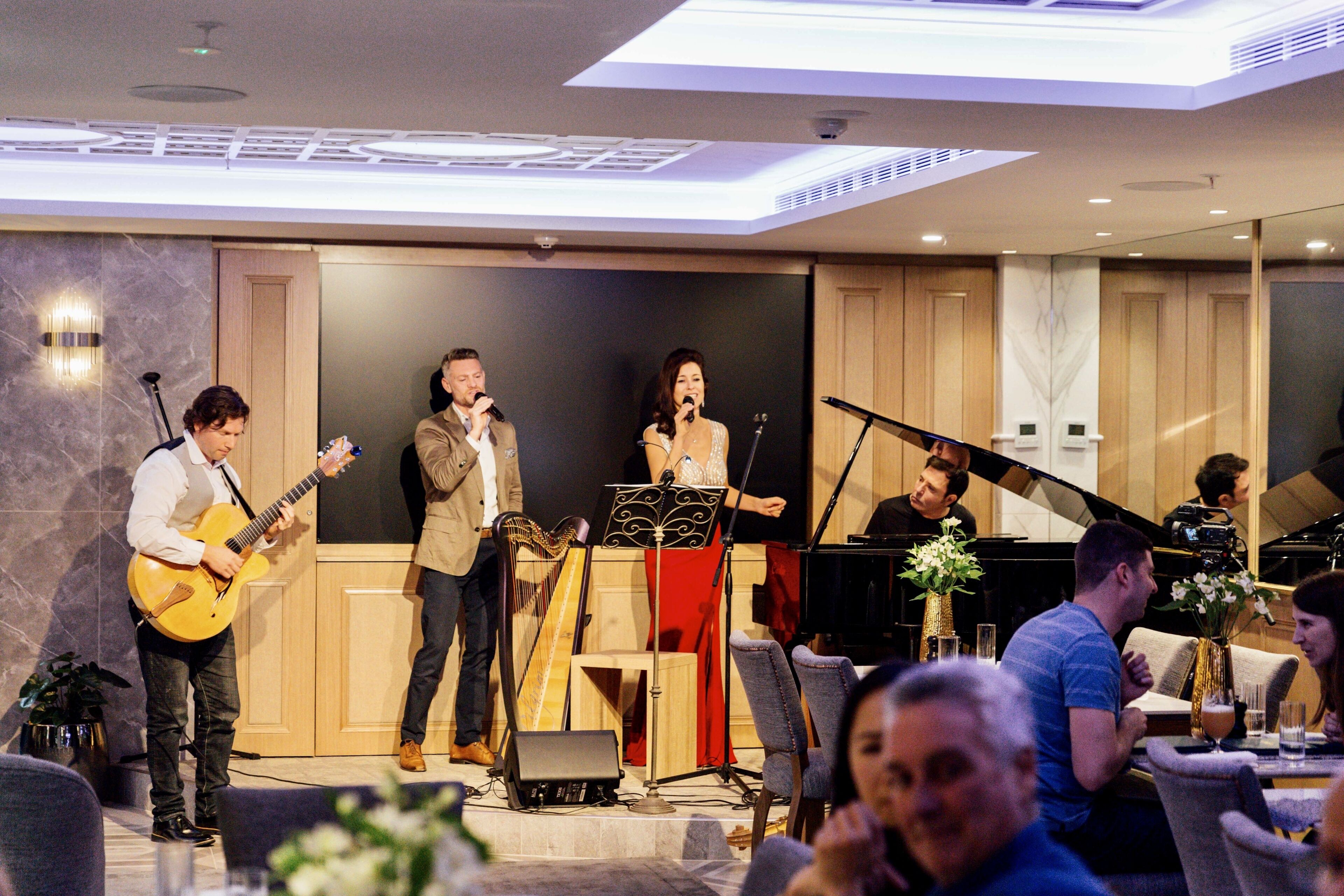A stage with musicians performing, a podium, and a piano.