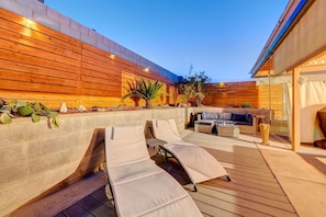 Relax in style on this outdoor patio with a sofa, table, and lounge chairs.