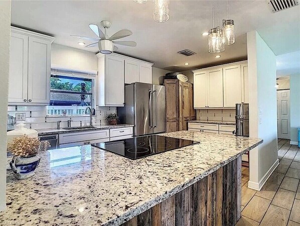 Enjoy cooking in this well-equipped kitchen with a sleek island, induction cooktop, and ample cabinetry.