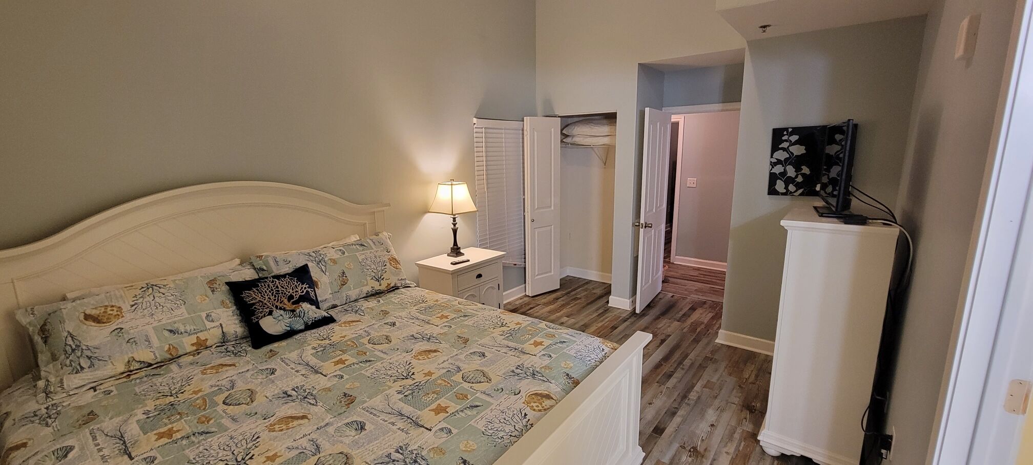 A bedroom with a bed, nightstand, and a wardrobe.