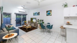 Ein modernes Wohnzimmer mit Fernseher, Sitzecke und Essbereich.
