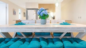 Eine moderne Küche mit Holzausstattung, einer zentralen Kochinsel und einem Blumentopf.