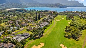 A golf course with a view of the ocean and mountains in the background.