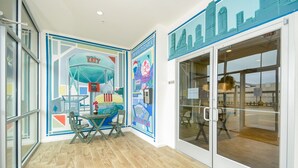 Een modern interieur met een stadsgezichtsmural, een glazen deur en een houten vloer.