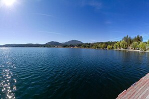 A calm lake with a mountain in the background and a wooden dock extending into the water.