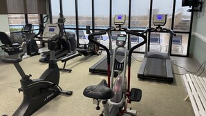A gym with various exercise equipment, large windows, and a view of the outside. - Romantic One-bedroom Condo in Orange Beach - Beautiful Gulf-front Views. (Orange Beach)