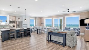 Un espacio habitable amplio con cocina, comedor y vista al océano.