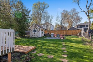 A backyard with a wooden deck, a small shed, and a stone pathway. - 🏡 Cozy Family Cottage Retreat | Beach • BBQ • Fire Pit | Sleeps 5 (Innisfil)